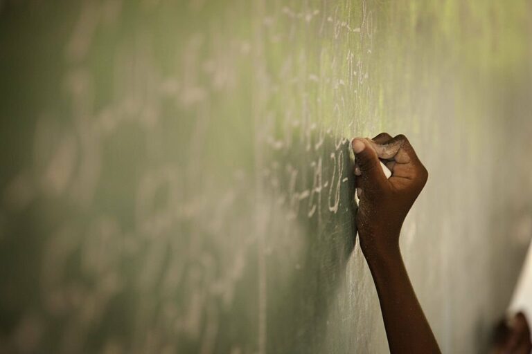 Young child writing on chalkboard in a school in Haiti